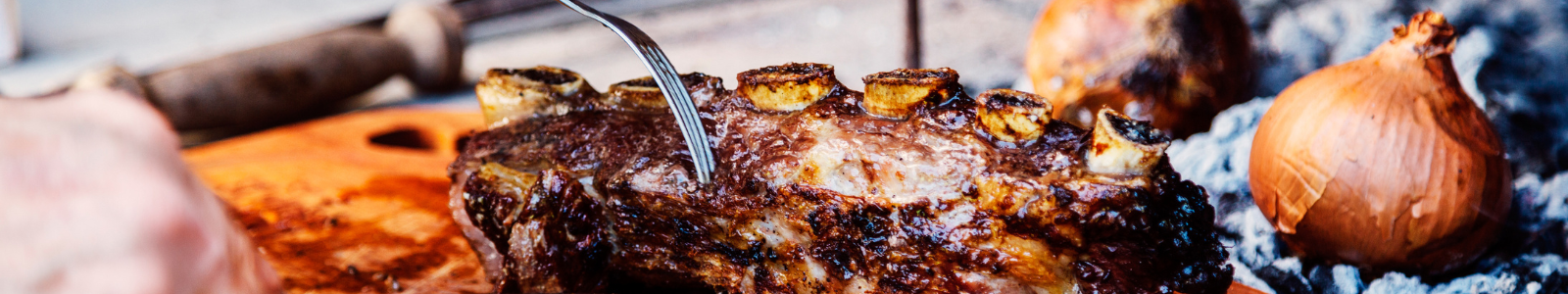 Parrilla con carne argentina cocinándose al fuego.