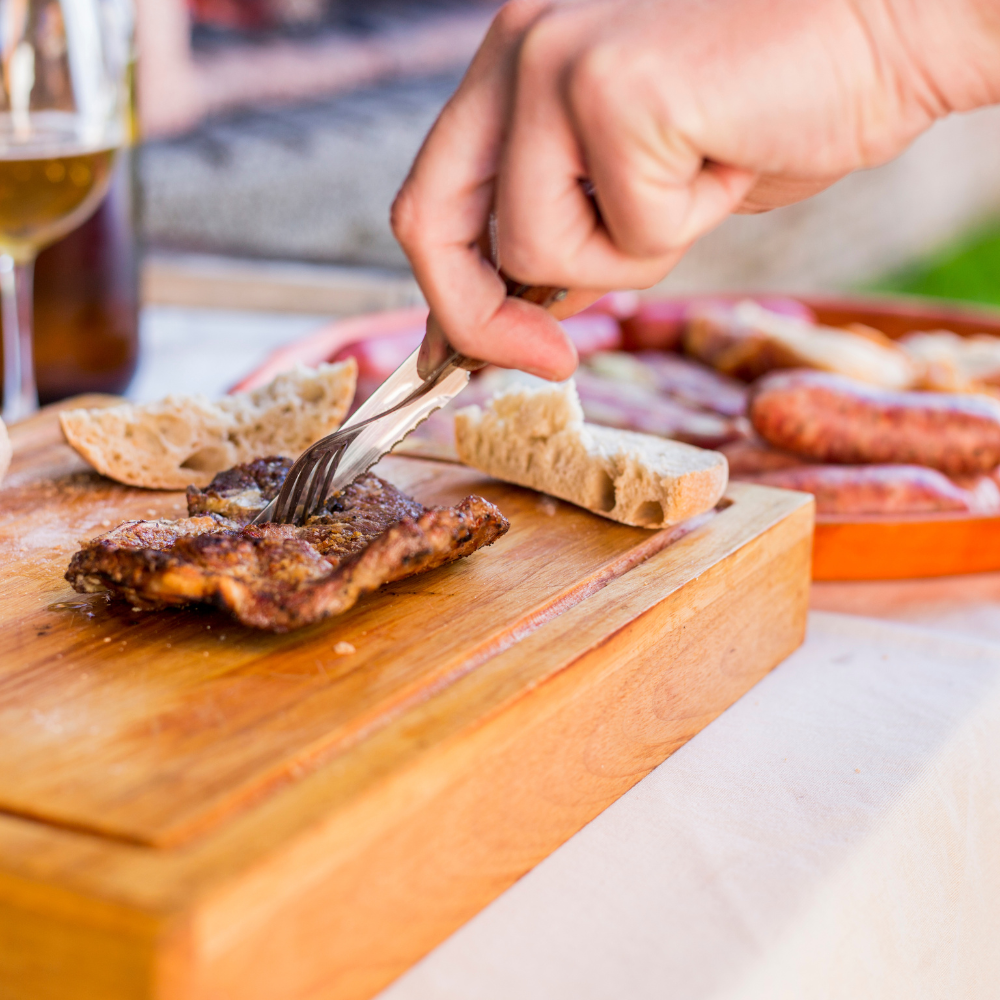 Degustación de un asado argentino en una mesa al aire libre.