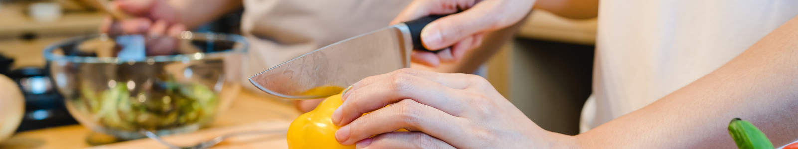 Docente enseñando técnicas de cocina a un grupo de alumnos.